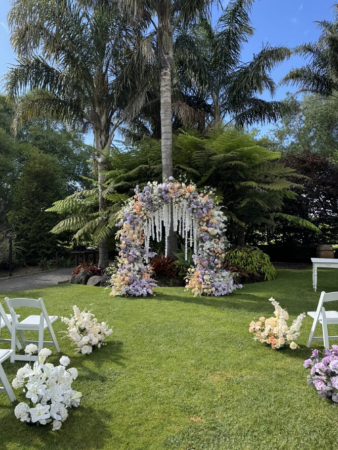 Purple and orange floral wedding arch setup at The Palms Ceremony location at Markovina Estate in Kumeu