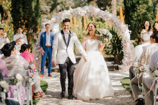 Happy weddiung couple walking down the Aisle at Markovina Estate in Kumeu