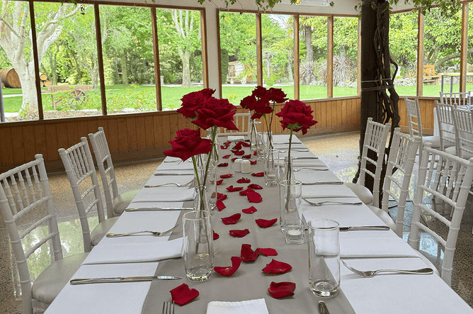 Table set up decorated with roses and rose petals