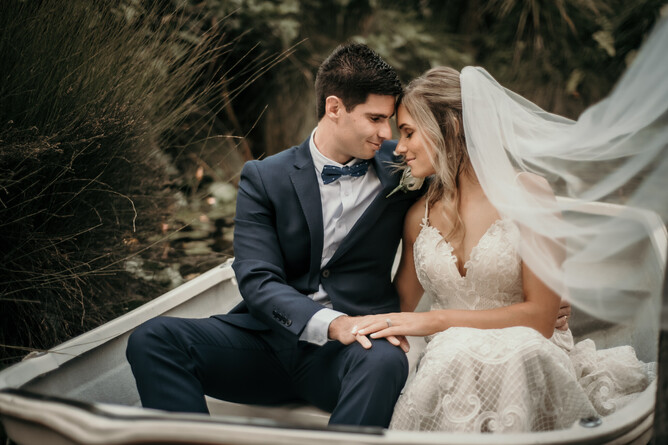 Bride & Groom taking wedding couple photo in boat at Markovina Estate in Kumeu, Auckland