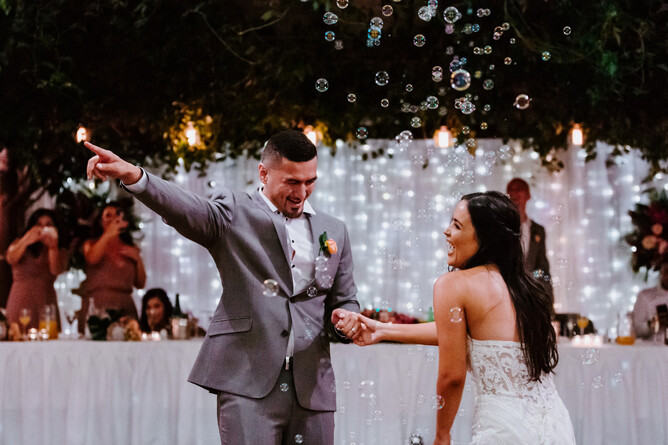 Wedding couple celebrating under the vines at Markovina Estate in Kumeu