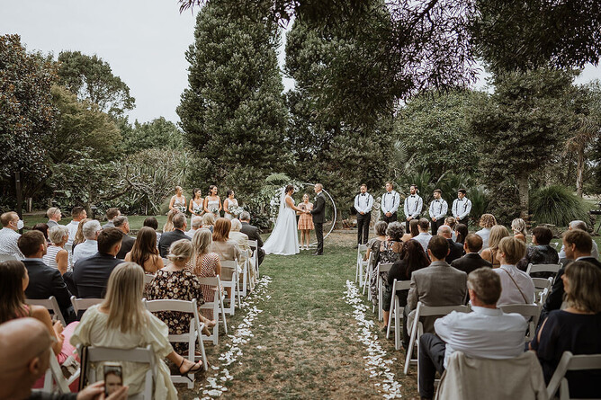 Wedding couple saying their vows during their ceremony at the Two Kauri Trees at Markovina Estate in Kumeu