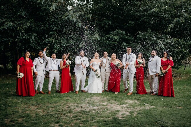 Bridal party photo with red bridemaids dresses at Markovina Vineyard Estate in Kumeu