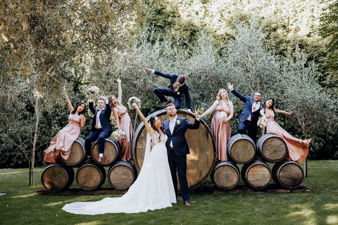Bridal party taking photos at The Barrels Ceremony location at Markovina Estate in Kumeu