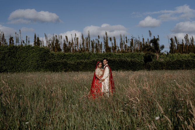 Indian wedding couple standing in a field