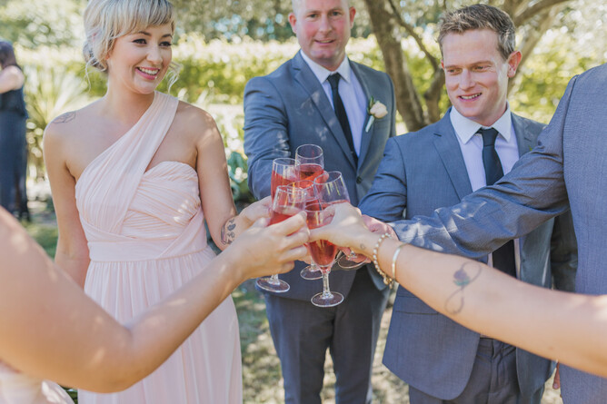 Wedding guests enjoying a glass of bubbles during the reception at Markovina Estate in Kumeu