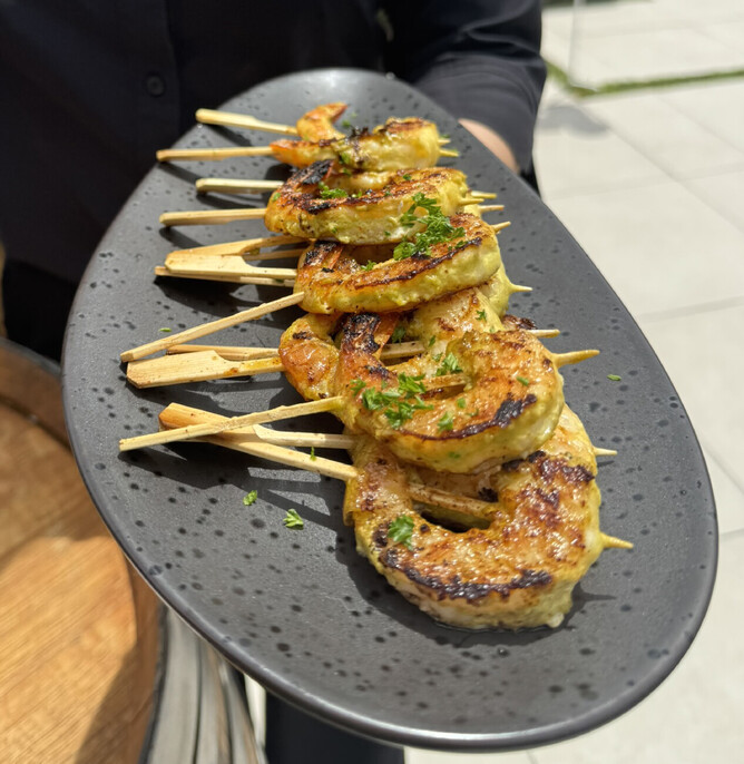Garlic, parsley and chilli prawn skewers cooked on the grill in the garden and served directly to the guests