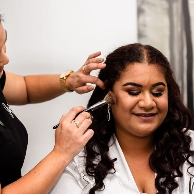 Mele getting her makeup done on her wedding day