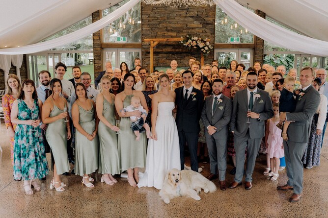 Wedding group photo at the indoor stone fireplace at Markovina Estate in Kumeu