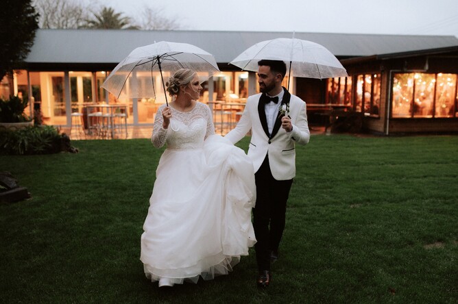 Wedding Couple Photo with Umbrella in Rain at Markovina Vineyard Estate in Kumeu