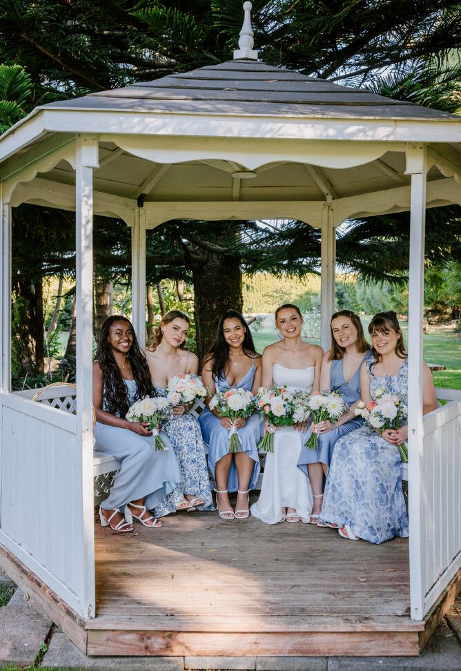 Bride & Bridesmaids sitting in The Pergola at Markovina Estate in Kumeu, Auckland