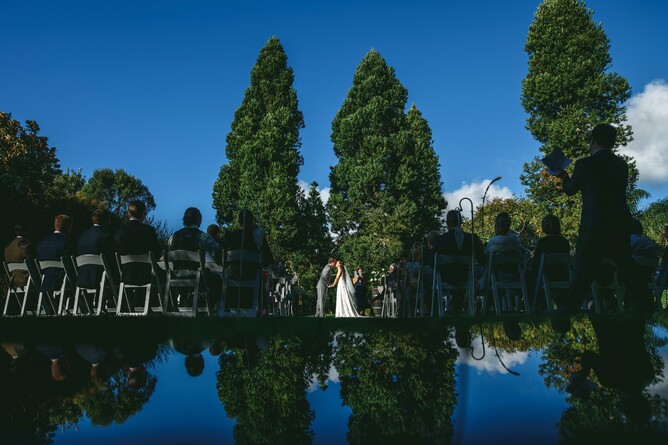Wedding couple having their summer wedding ceremony at The Two Kauri Trees at Markovina Estate in Kumeu