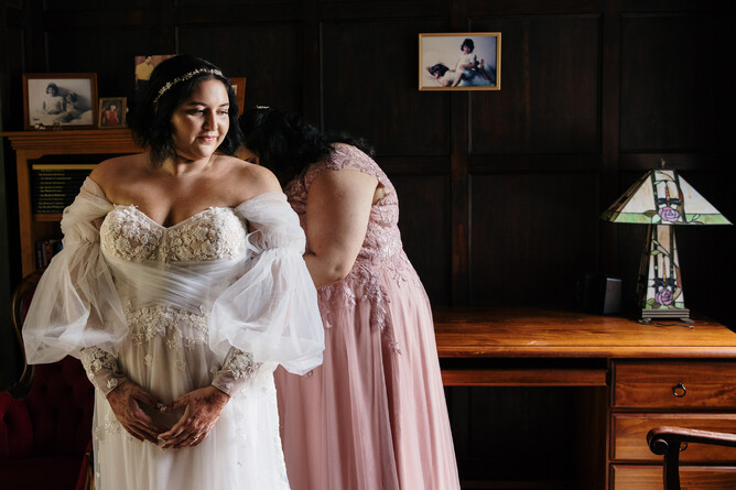 maid of honor fixing the bride's dress