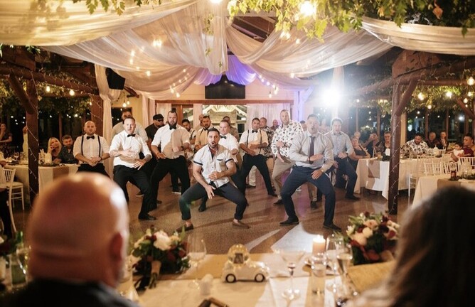groomsmen dancing in front of the bridal table
