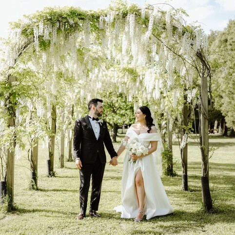 bride and groom walking under the arches