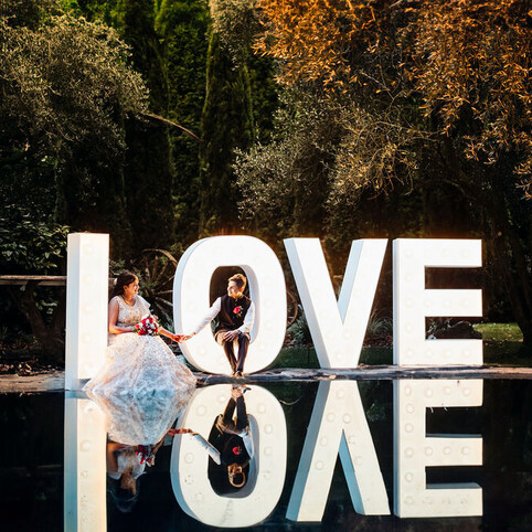 wedding couple posing at love sign