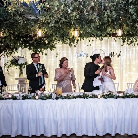 Bride & groom kissing at bridal table