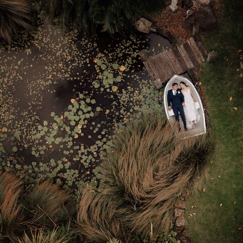 wedding couple posing lying down on a rowboat