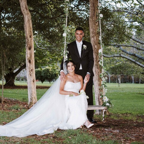 bride and groom posing by the swing