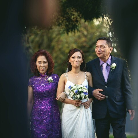 bride walking down the aisle with both parents