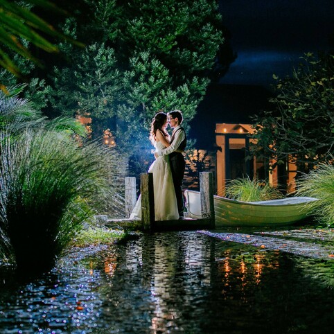 wedding couple posing by the boat at night time