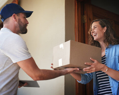 Man handing woman a box of printing
