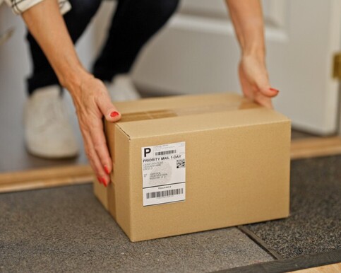Man handing woman a box of printing