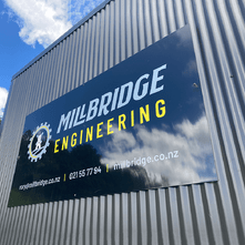 Large vinyl sign on the side of a corrugated building