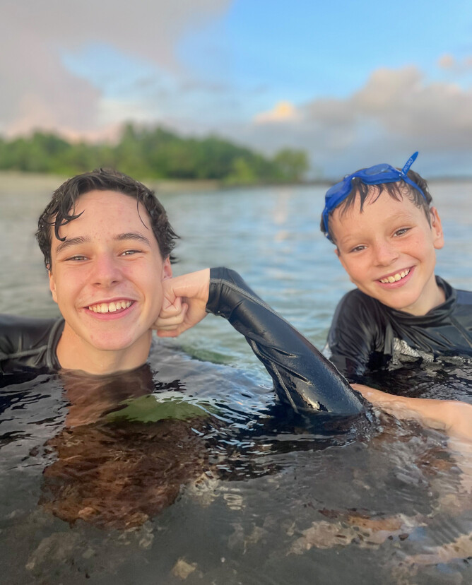 Josh and Caleb playing at the beach with 'Logan Hogan', a log that was briefly adopted into the family.
