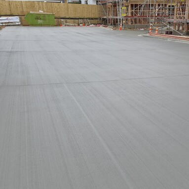 large outdoor concrete for a shared driveway area, concrete is dark and smooth with a slight brushed texture