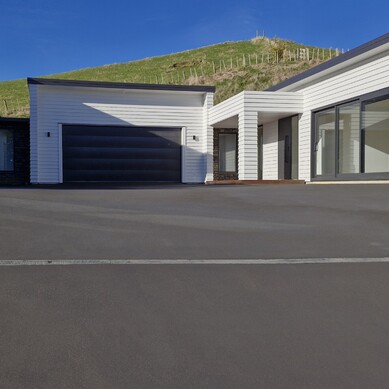 large smooth concrete driveway in-front of white house
