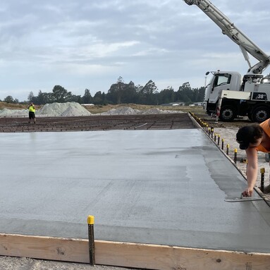 large concrete floor being laid by concrete workers