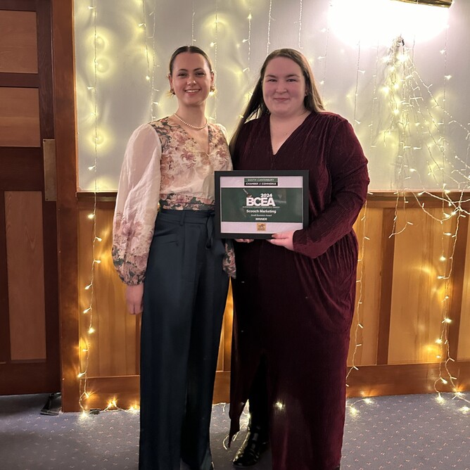 Team members Nina and Miranda from Scooch Marketing, Timaru, at the Business Community and Excellence Awards 2024, hosted by the South Canterbury Chamber of Commerce. The image captures the agency's celebration of their achievements in graphic design, social media management, and digital marketing services.