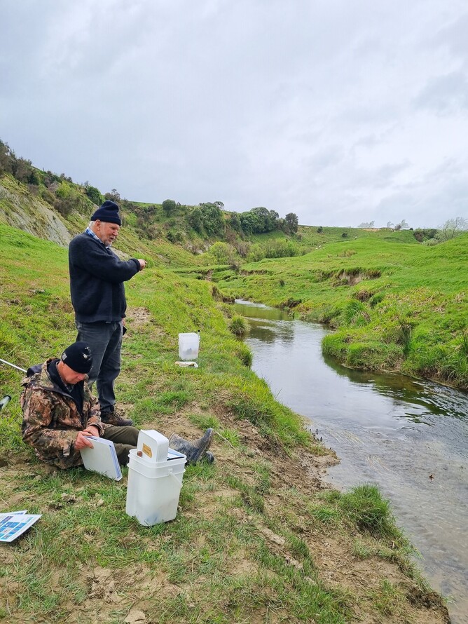 Two people checking water quality in the Wainuioru Catchment