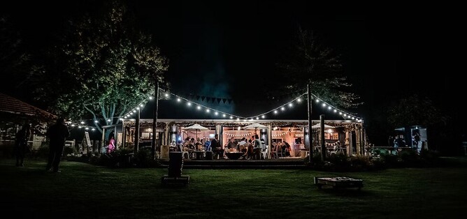 night time shot of lights and a reception wedding party at Te Miro Woolshed Wedding venue near Cambridge