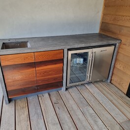 Outdoor bar, concrete tops cedar weatherboards for doors.