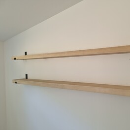 Custom timber shelving with wall brackets.