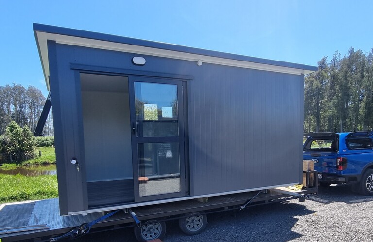 4.6m x 2.7m grey cabin on a trailer ready for delivery.