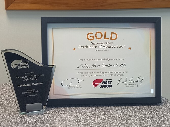 Photo of Strategic Partner trophy presented to AIL of New Zealand beside Gold Sponsorship Certificate of Appreciation presented to AIL of New Zealand Ltd