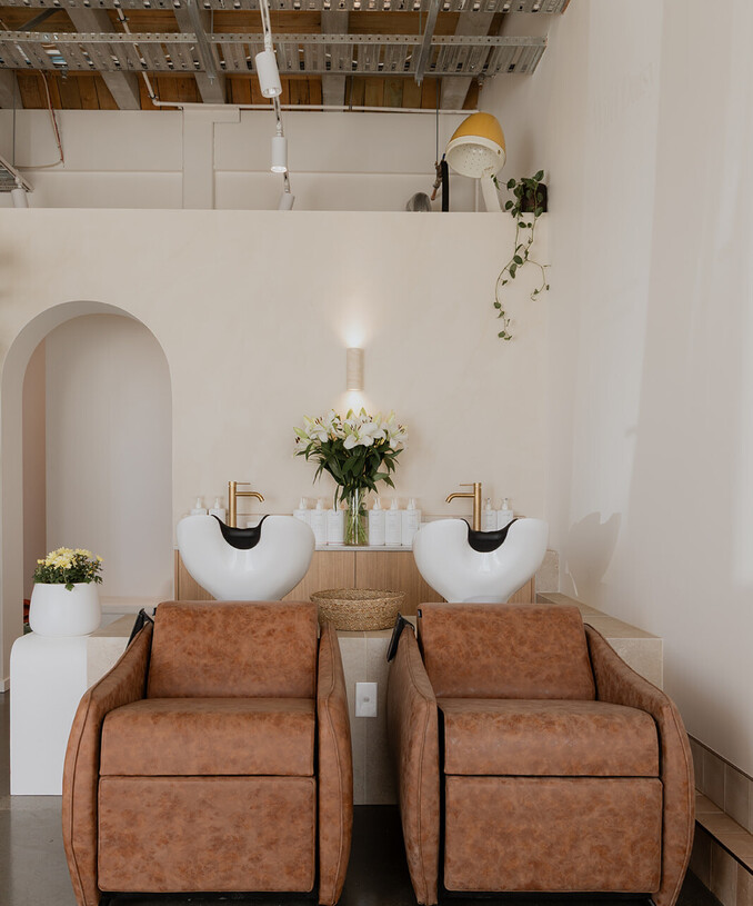 The shampoo basins and chairs at Wild Daisy hair in Frankton with haircare behind.