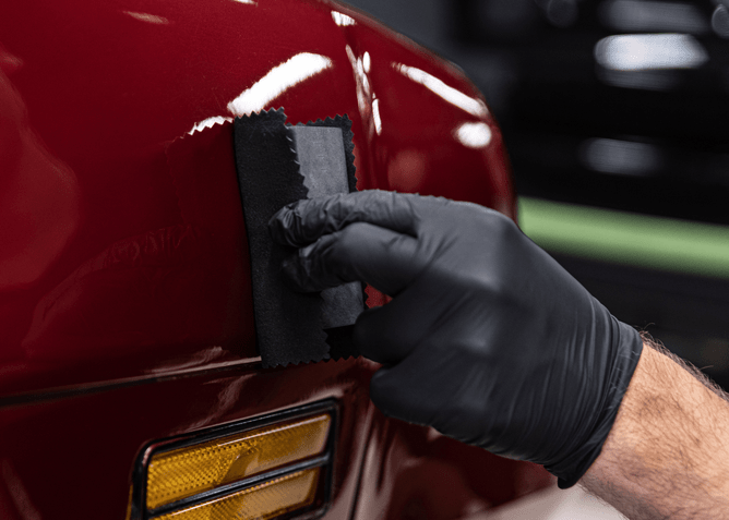 ceramic coating being applied to a car by professional detailer