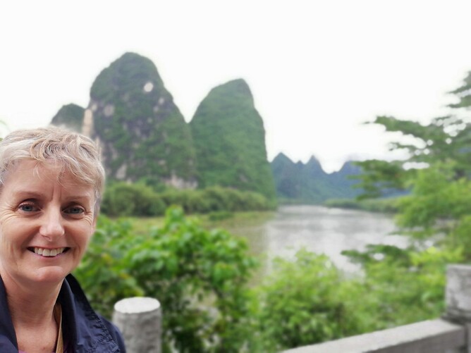 Woman by jagged kaarst mountains in China.