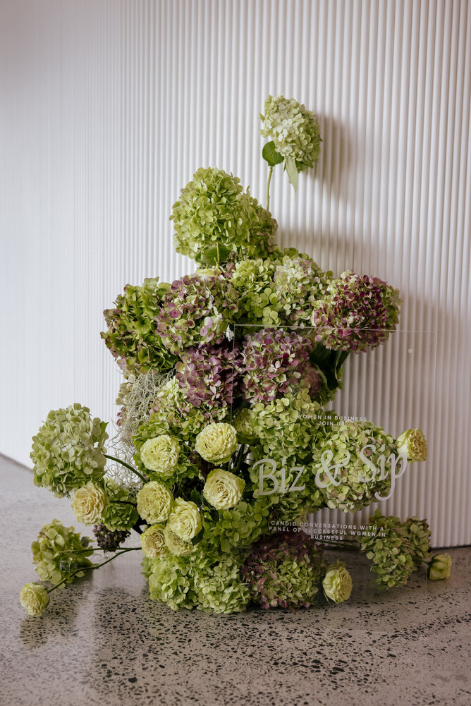 Beautiful event floral arrangement from sponsors Flora Kai and signage from sponsors inHouse.