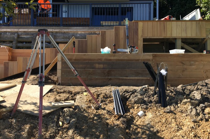 Setting heights during a landscaping construction project with timber retaining wall in Nelson