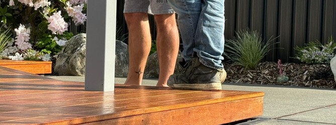 Sherlock Landscaping team discussing deck construction in Nelson — timber deck and garden design.
