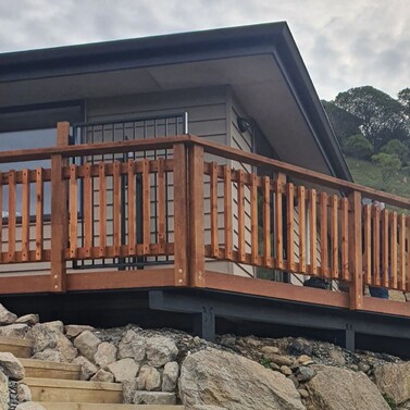 Timber balcony fence with retaining wall and stone steps in Nelson home