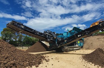 Powerscreen Warrior 1200 screening machine processing soil into different grades using 3 conveyor arms to stockpile the soil grades