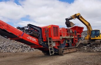Terex Finlay J-1175 heavy duty tracked jaw crusher machine being loaded by excavator