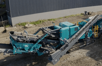 Aerial view of a Powerscreen Trakpactor 260SR rock crusher, crushing waste concrete for recycling into recycled crushed concrete aggregate