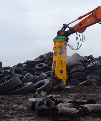 Indeco ISS shears being used to cut up old heavy machinery tyres in a tyre recycling yard